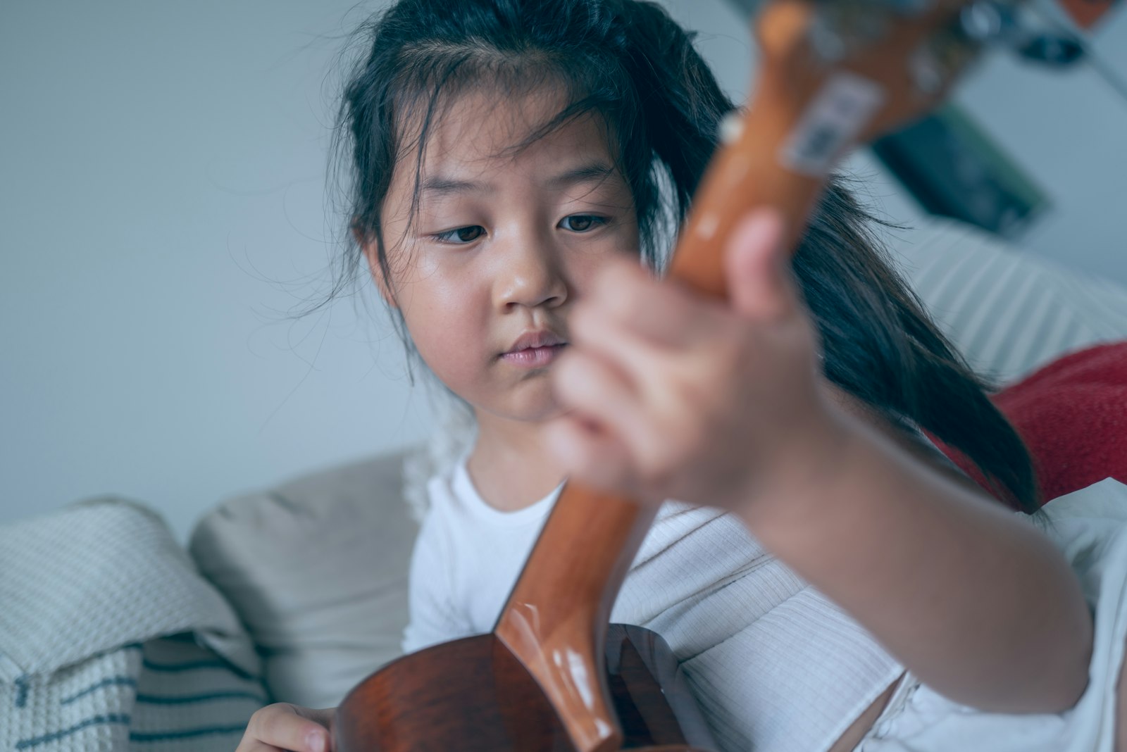 Child learning ukulele at Kaleidoscope Arts Studio